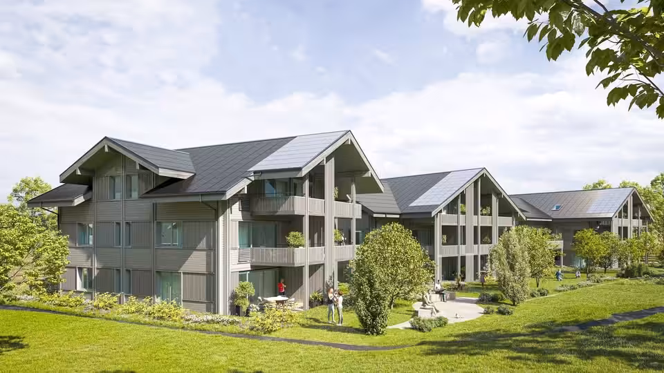 Moderne Wohnanlage mit grüner Umgebung und blühenden Bäumen an einem sonnigen Tag - Nachhaltige Architektur im Grünen.